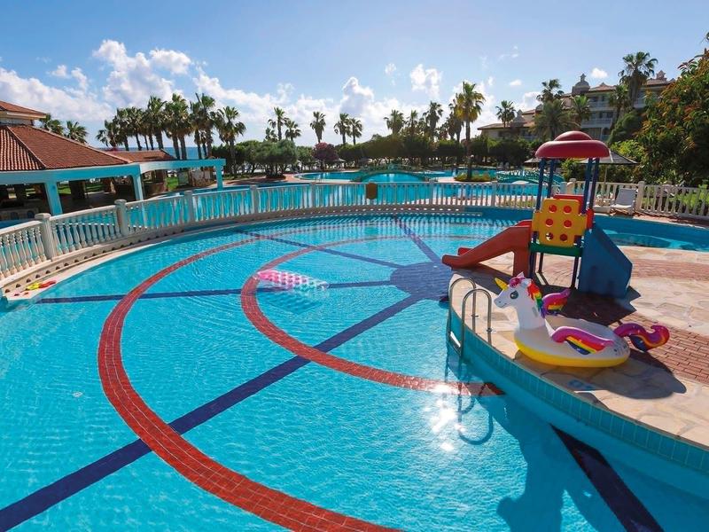 Velký bazén s odděleným dětským bazénem a herním vybavením v rekreačním středisku.