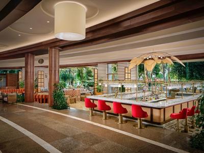 Moderner Hotel-Lobbybereich mit Sitzgelegenheiten und großen Fenstern mit Blick auf die Natur.