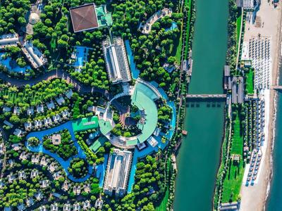 Luftaufnahme eines Resorts mit Pool, Fluss und Strand am Meer