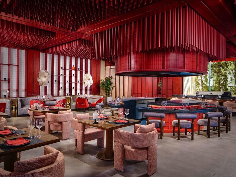 Modernes Restaurant mit roten Akzenten, bequemen Stühlen und dekorativen Pflanzen
