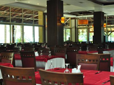 Restaurant élégant avec mobilier en bois et tables rouges dans un hôtel.
