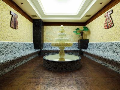 Couloir d'hôtel avec fontaine au centre, murs décoratifs et plantes