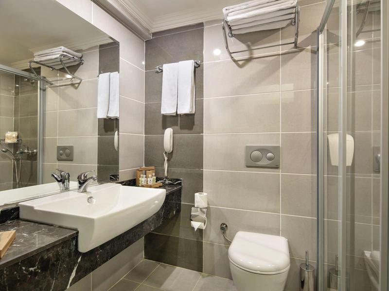 Salle de bain moderne avec lavabo, toilettes et cabine de douche en verre.