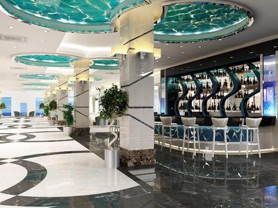 Moderner Innenraum mit beleuchtetem Barbereich, geometrischem Bodenmuster und grünen Deckenakzenten.