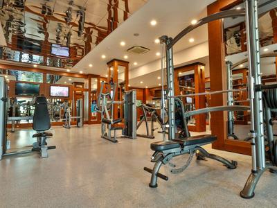 Modern gym equipment with weight benches and mirrors in a hotel