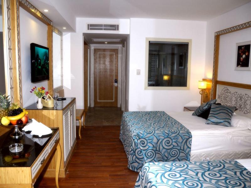 Vodní skluzavky a síťové hřiště v venkovní části resortu za slunečného dne.