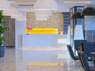 Reception moderna della hall dell'hotel con banco luminoso e motivo decorativo sulla parete