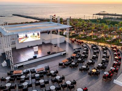 Palco all'aperto a teatro con posti a sedere vicino al mare al tramonto.