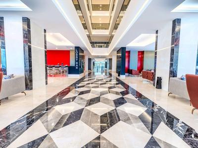 Hall d'hôtel moderne avec sol en marbre noir et blanc et zones d'assise élégantes.