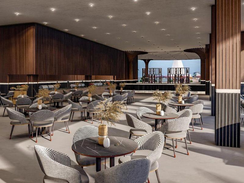 Restaurant moderne avec tables rondes et chaises grises dans un espace lumineux et spacieux.