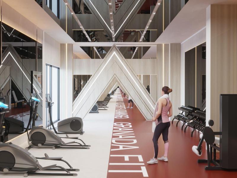 Salle de sport moderne avec miroirs, tapis de course et elliptiques dans un design clair.