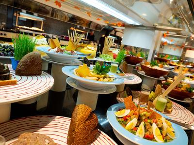 Buffet mit verschiedenen Gerichten auf runden Tischen in einem Restaurant