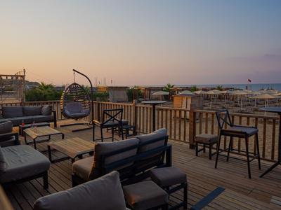Dachterrasse mit Sitzgelegenheiten und Blick auf die Stadt bei Sonnenuntergang.