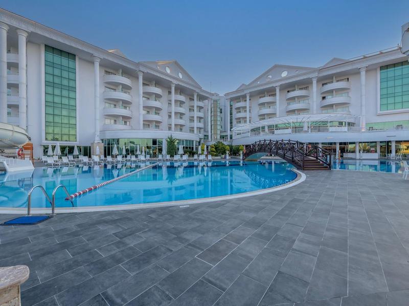 Hotel moderno con grande piscina all'aperto e terrazza soleggiata sotto un cielo limpido