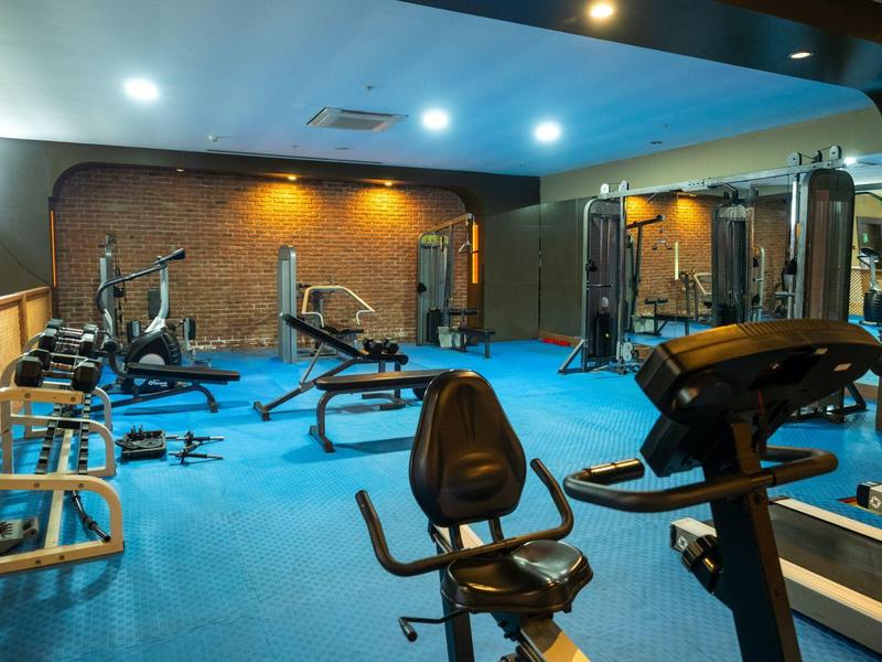 Attrezzature da palestra moderne con vari dispositivi in una stanza ben illuminata.