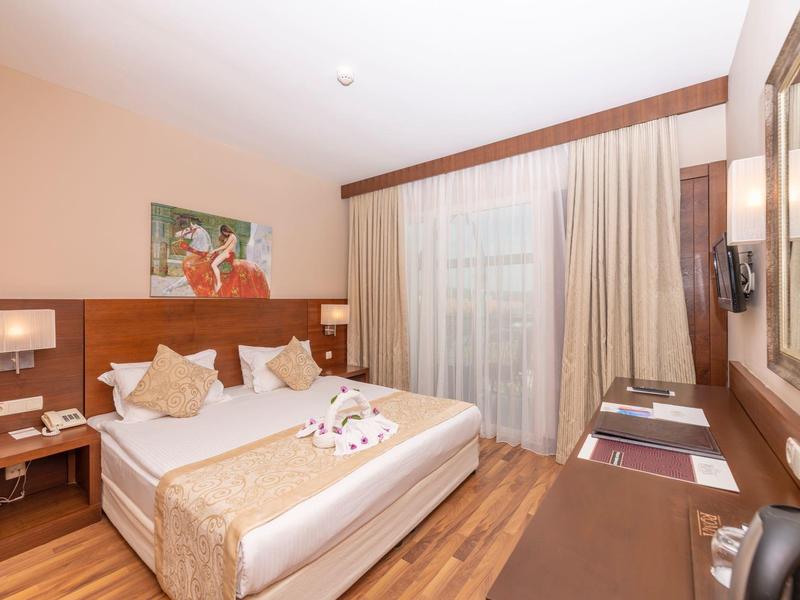 Camera d'hotel accogliente con letto matrimoniale, scrivania e arredamento moderno