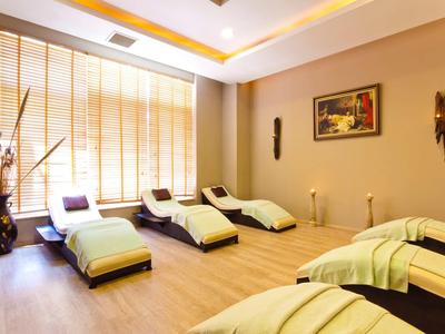 Lichte wellnessruimte met ligstoelen, houten vloer en decoratieve wandkunst.