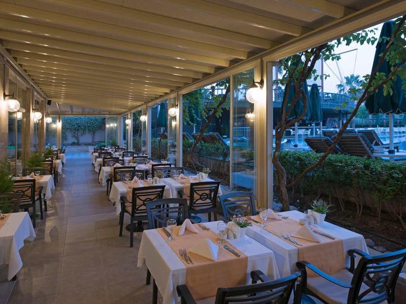 Widok na elegancką, otwartą restaurację z nakrytymi stołami na zewnątrz.