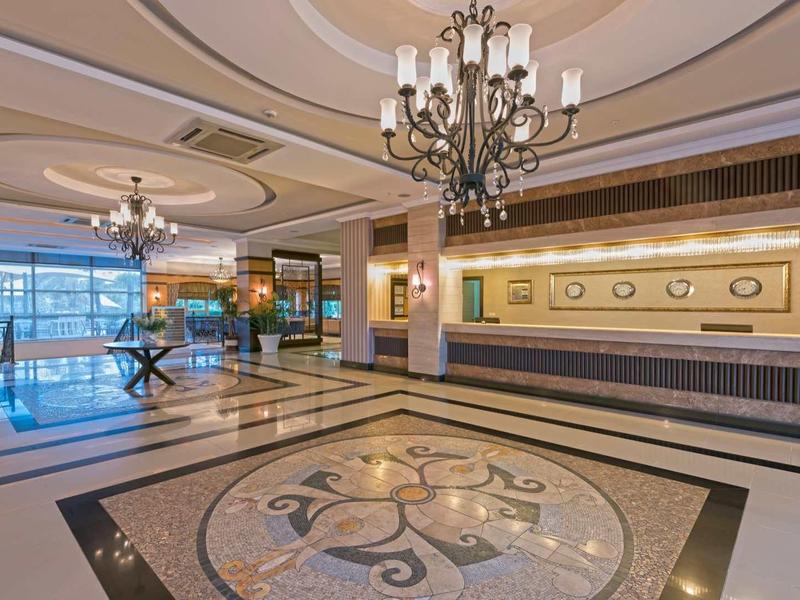 Duża hotelowa hol z mozaikową podłogą i żyrandolami w eleganckim stylu.