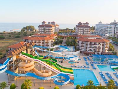 Großes Hotel mit mehreren Wasserrutschen und Poolbereich in Strandnähe.