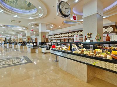 Amplia zona de buffet con variedad de alimentos y suelo de mármol claro en un hotel.