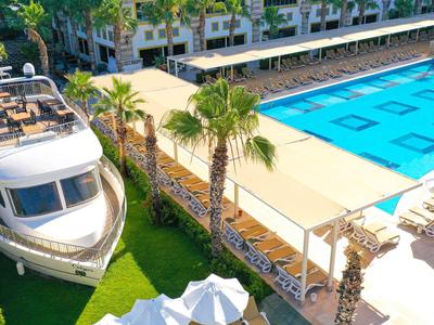 Gran piscina al aire libre con tumbonas y un barco en un jardín bien cuidado