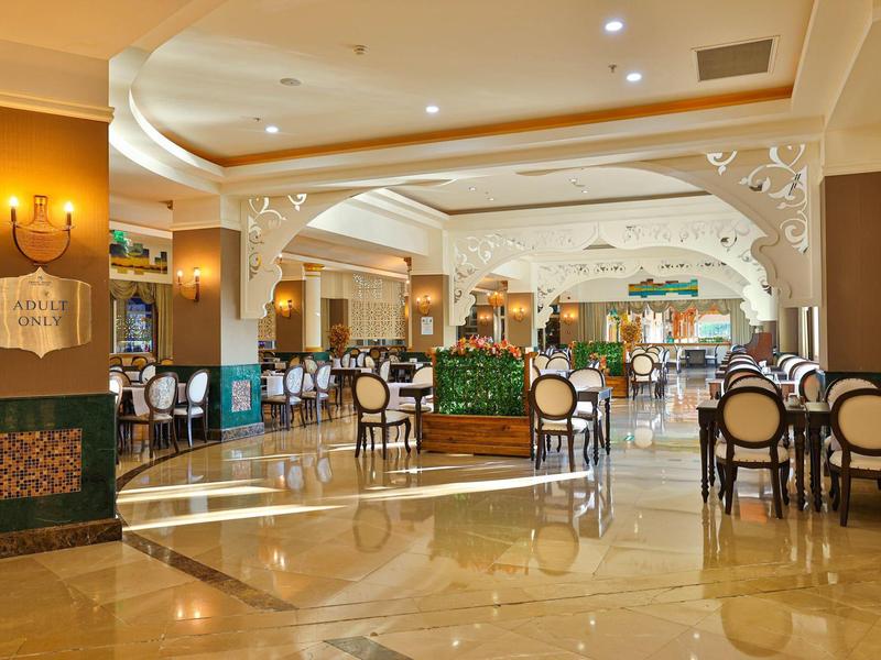 Amplio y elegante comedor de hotel con suelo de mármol brillante y mesas redondas.