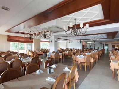 Duża jadalnia z elegancko nakrytymi stołami i wygodnymi krzesłami w hotelu.