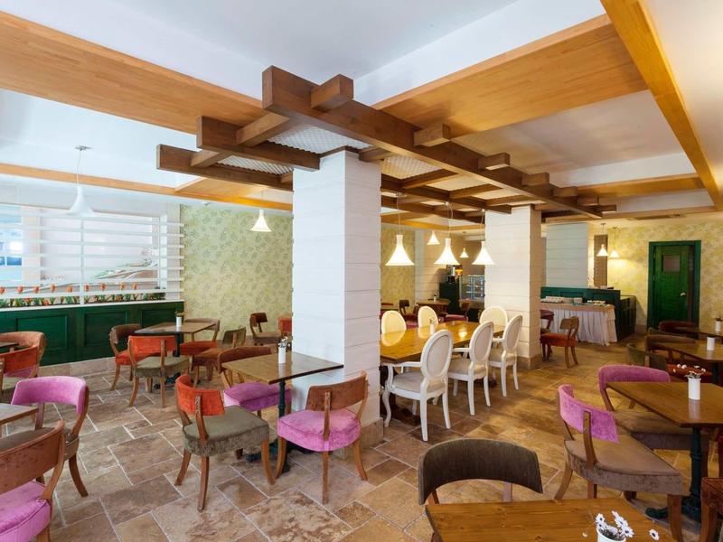 Przytulna jadalnia z kolorowymi krzesłami i drewnianymi stołami w hotelu.