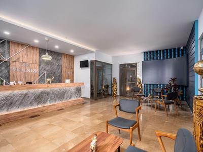 Moderner Hotel-Lobby-Bereich mit Rezeption, Sitzecken und stilvoller Einrichtung in warmen Tönen.