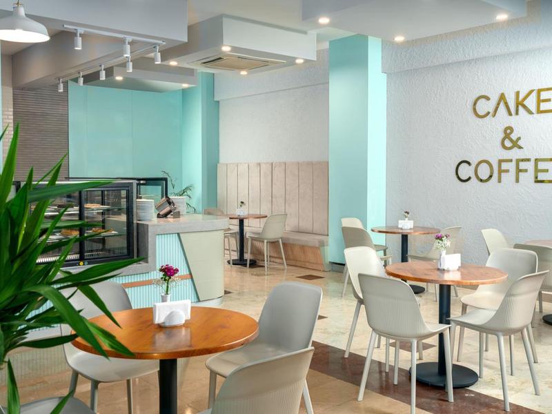 Moderne caféruimte met tafels, stoelen en Cake & Coffee wandbord.