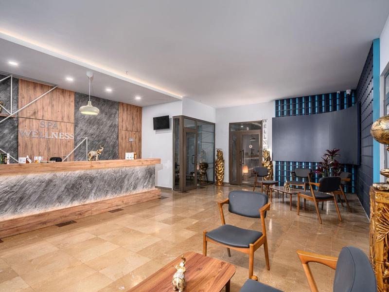 Moderne hotel lobby met balie, zithoek en decoratief interieur.