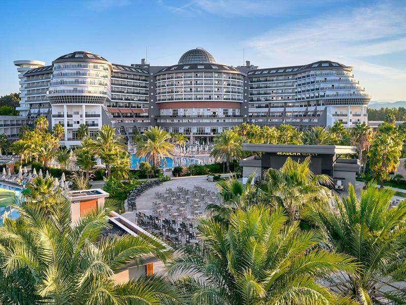 Complex moderne avec plusieurs piscines entouré d'une végétation tropicale luxuriante et de palmiers.