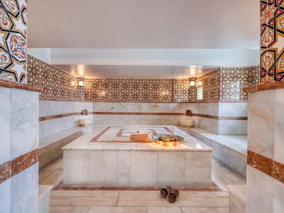 Weißer Marmor, braune Fliesenmuster, saubere Atmosphäre, warmes Licht, traditionelles türkisches Bad.