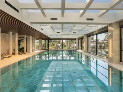 Innenpool in modernem Hotel mit großen Fenstern und Holzverkleidung.