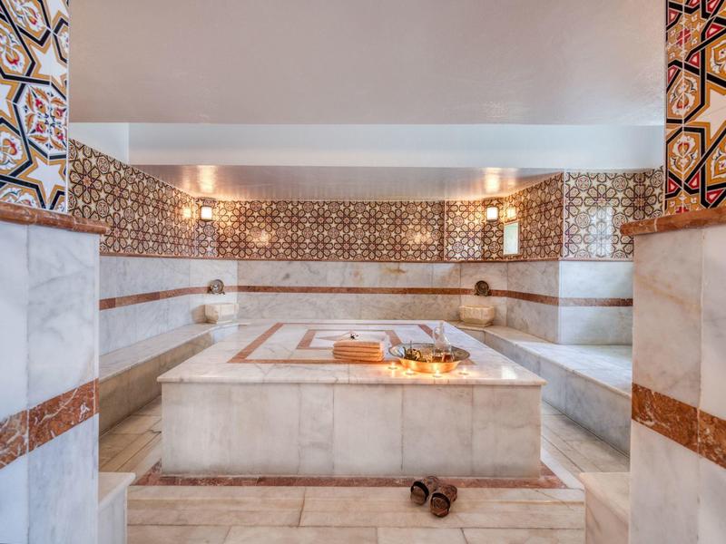 Weißer Marmor, braune Fliesenmuster, saubere Atmosphäre, warmes Licht, traditionelles türkisches Bad.
