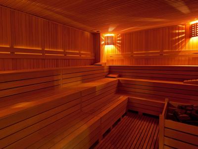 Lichte sauna met houten banken en warm licht, ideaal voor ontspanning in hotel.
