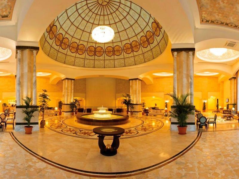 Ruime hotel lobby met bogenramen, sierlijke koepelplafond en stijlvolle zitgedeeltes.