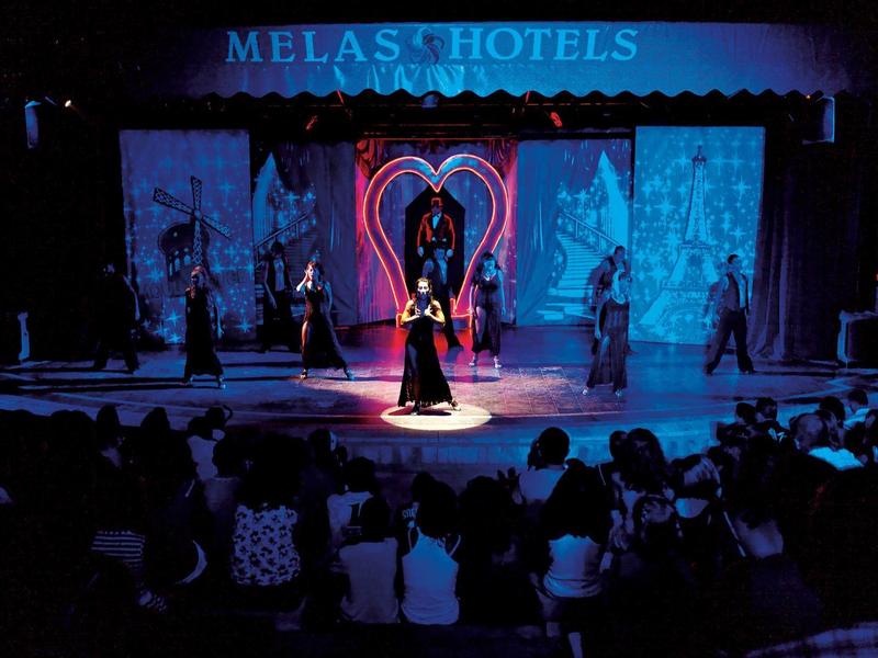 Spettacolo sul palco con decorazioni a forma di cuore e pubblico in una sala d'hotel