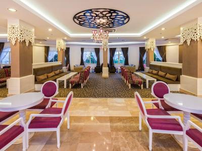 Elegancki salon z czerwonymi fotelami i nowoczesnym oświetleniem.