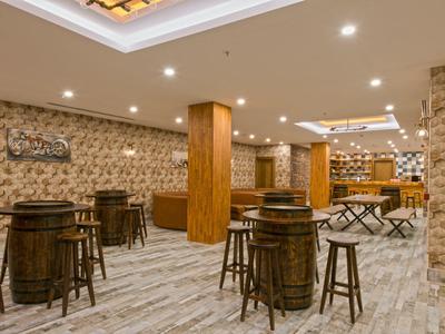 Bar de hotel acogedora con muebles de madera, barra y luz cálida, diseño elegante.