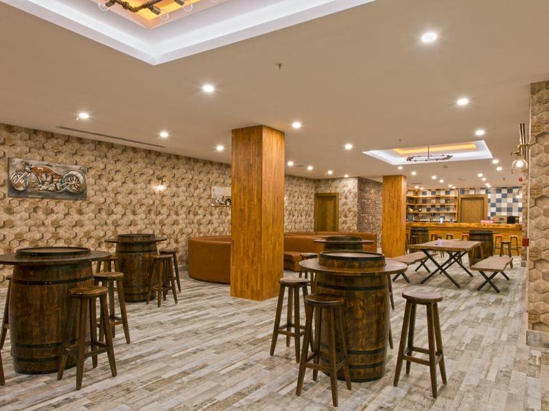 Bar de hotel acogedora con muebles de madera, barra y luz cálida, diseño elegante.