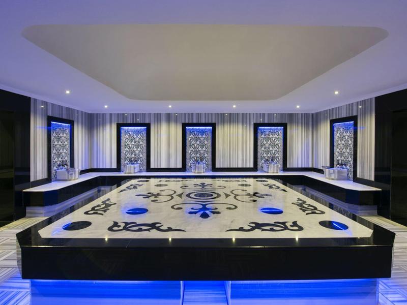 Sala de descanso de spa moderna con azulejos de mosaico y iluminación indirecta.