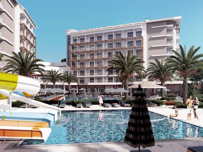 Modern hotelzwembad met glijbaan, ligstoelen en palmbomen onder een heldere lucht.