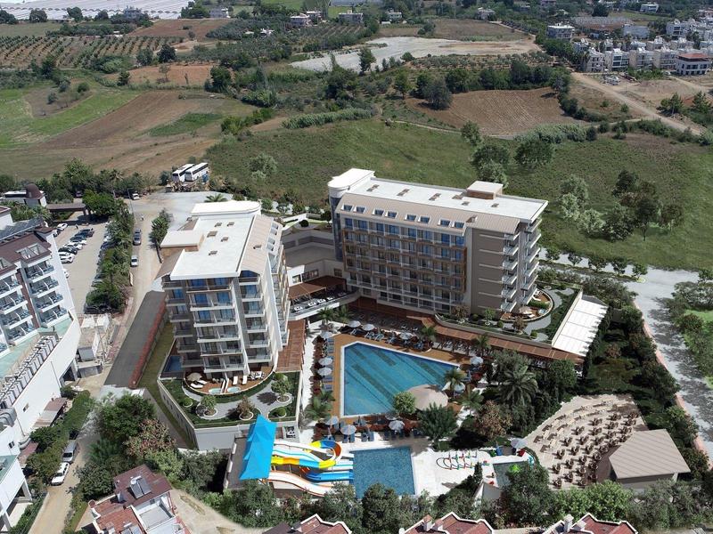 Luchtfoto van een hotel met meerdere gebouwen en een groot zwembad met glijbanen.