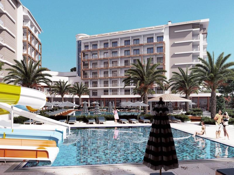 Modern hotelzwembad met glijbaan, ligstoelen en palmbomen onder een heldere lucht.