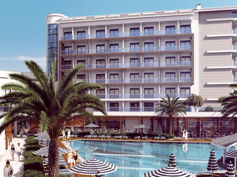 Modern hotel met groot zwembad en palmbomen onder een heldere hemel