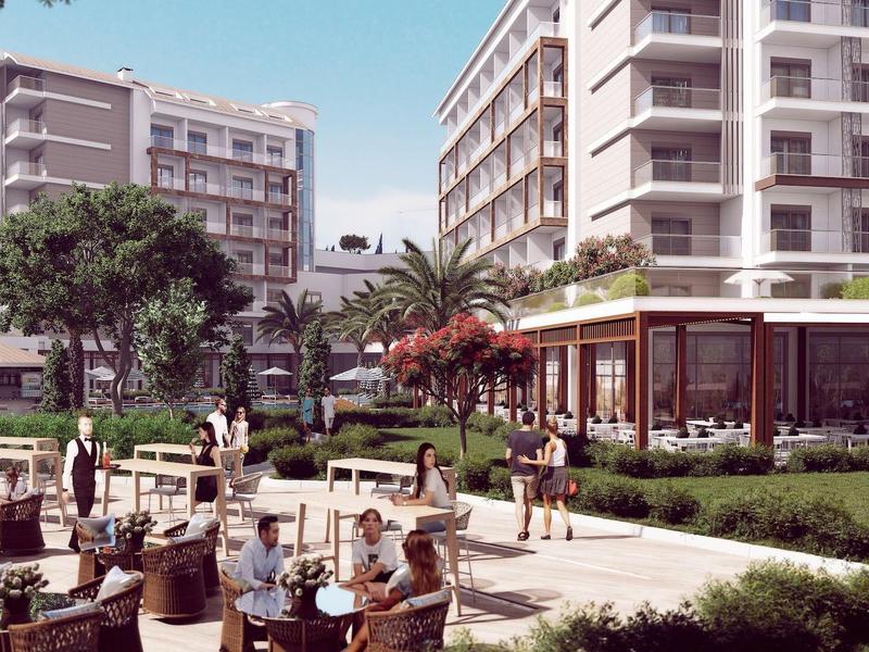 Hotelbinnenplaats met zitgedeeltes, bomen en meerlaagse gebouwen op de achtergrond.