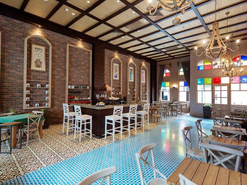 Interior de restaurante con iluminación cálida, azulejos decorativos y mesas con sillas en estilo vintage