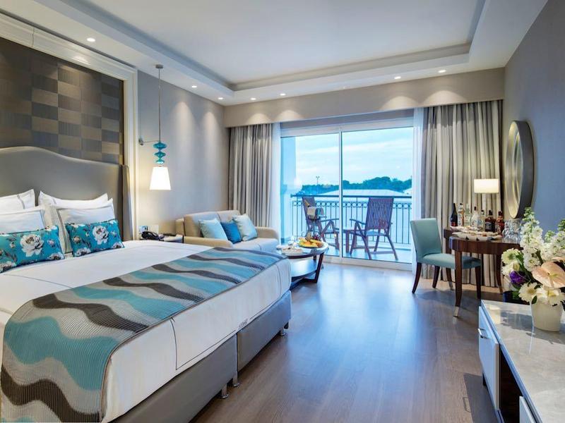 Habitación de hotel moderna con cama doble, ventana grande y vista a la ciudad.